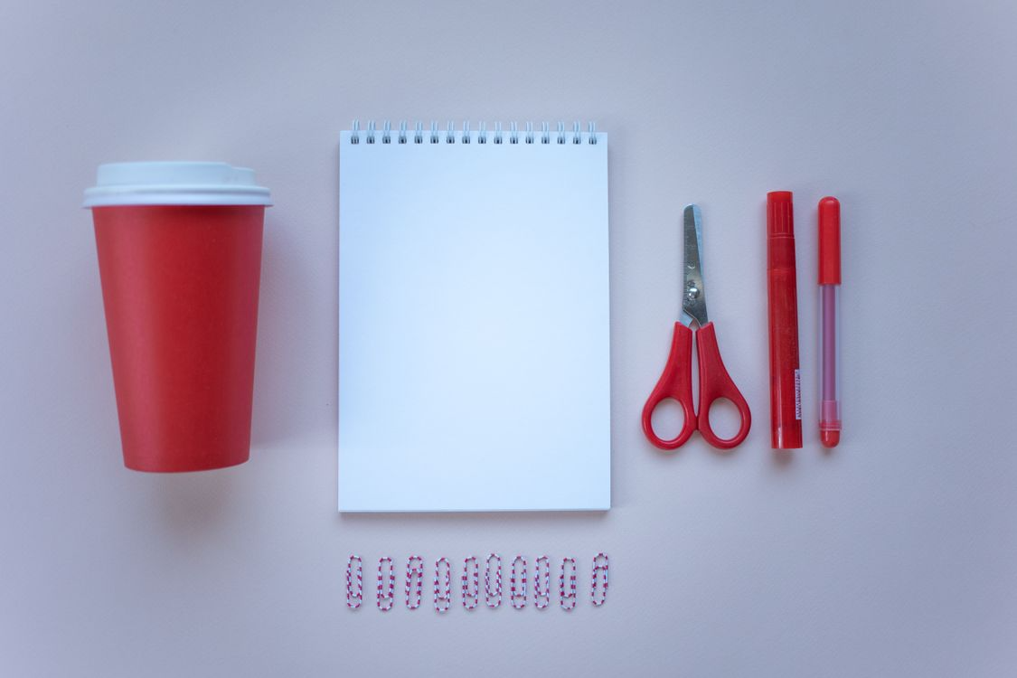 Scissors, paper clips, and notebook showing simple inventions that changed lives through everyday use