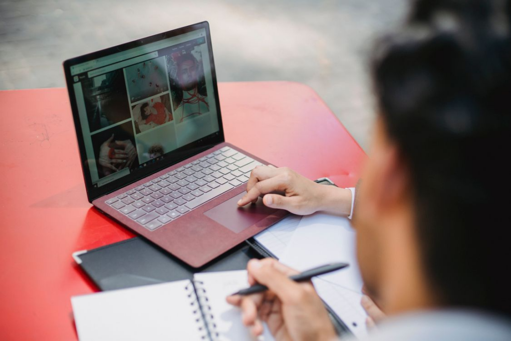 Person browsing visual content on a laptop showing virtual tours from home