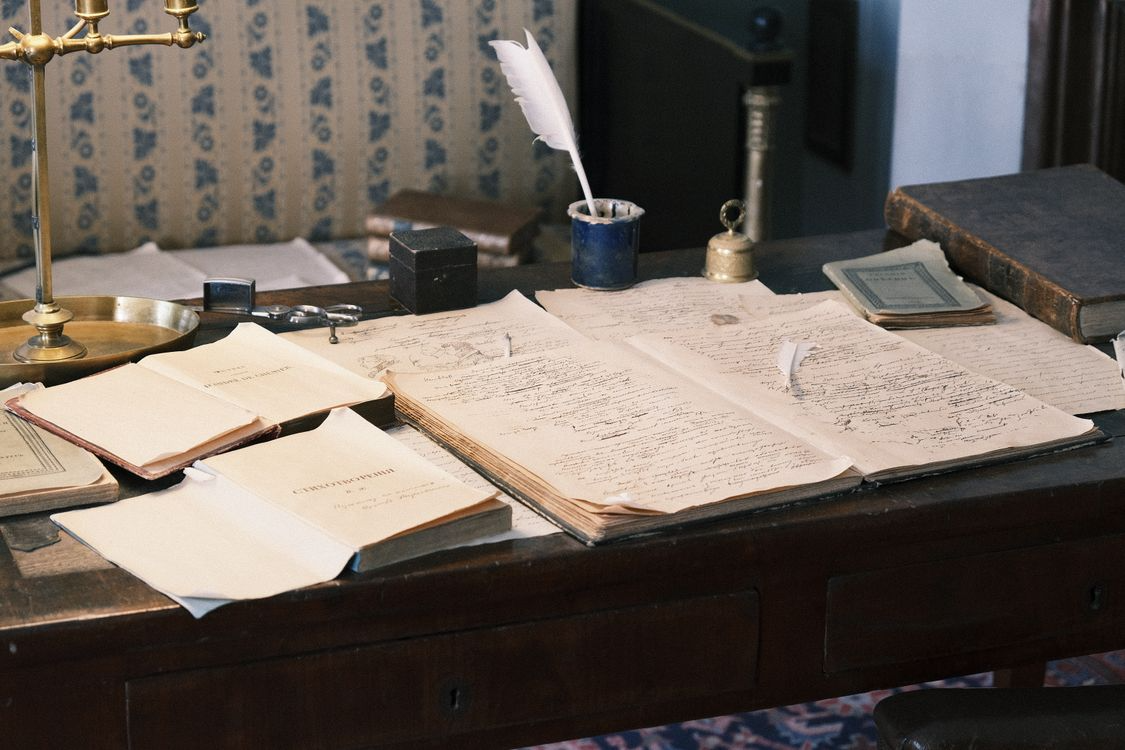 Old books and handwritten papers illustrating the origins of everyday expressions in language history