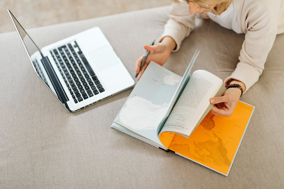 Reader using a laptop and book showing educational internet rabbit holes for curiosity-led learning